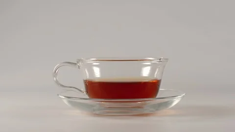 Drinking of black tea from a teacup on a white background - Stop motion Stock Footage 93725480