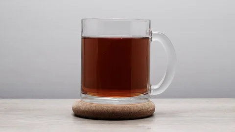 Drinking of black tea from a teacup on a white background - Stop motion. TIME Stock Footage 107209126