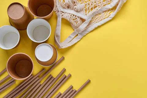 Drinking brown tubes straws made of paper and cornstarch, mesh market bag and Stock Photos