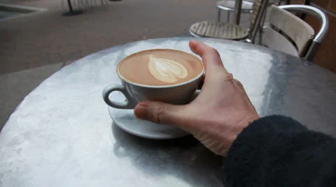 Drinking a cappuccino at an outdoor cafe Stockbeeldmateriaal 24517000