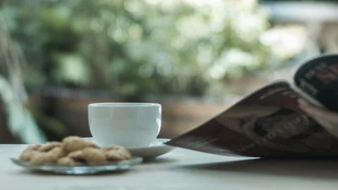 Drinking coffee and reading a magazine on nature background Stock Footage 236730563