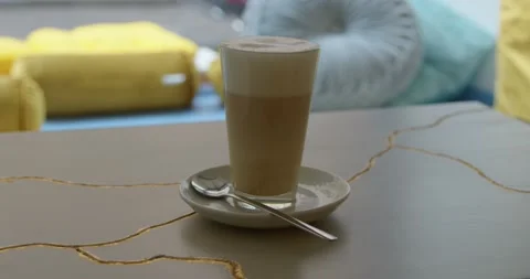 Drinking coffee, a delicious cappuccino on the table in the cafe. Close-up. Stock Footage 221154090