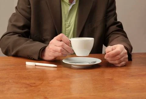 Drinking coffee at desk with pen Stock Photos