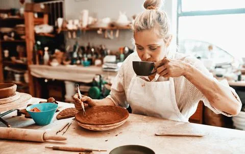 Drinking coffee, pottery and creative woman in workshop for carving pattern or Foto stock
