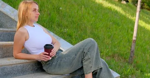 Drinking Coffee on the Steps in the Sunshine 库存照片