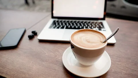 Drinking coffee while working on laptop in cafe Stock Footage 137907756