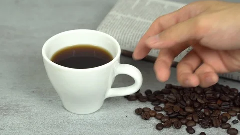 Drinking coffee white cup with coffee beans and newspaper Stock Footage 113003588