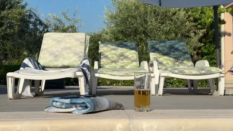Drinking a cold beer in the pool, sun lounger on the edge of the pool, towe.. 動画素材 339666998