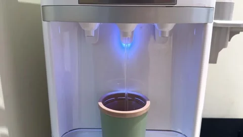 Drinking cooler pours cool clean water into mug in office during hot weather Stock Footage 306124436