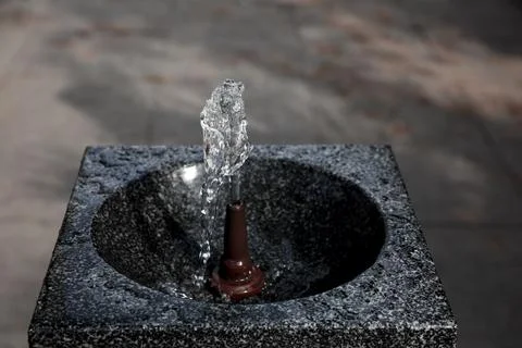 Drinking fountain with running water on city street Stock Photos