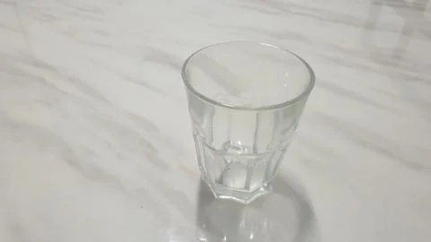 Drinking glass on white ceramic table Stock Photos