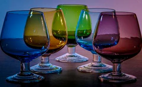 Drinking glasses of primary colours arranged symmetrically Stock Photos