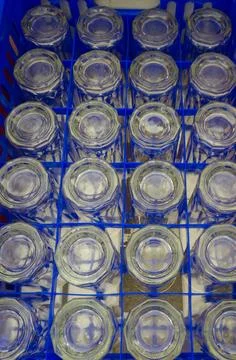 Drinking glasses was placed upside down in a blue plastic box Stock Photos