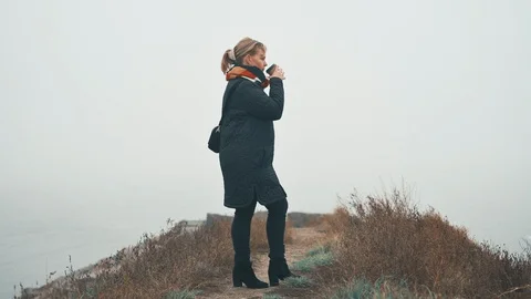 Drinking hot drink outside in cold weather in the fog Stock Footage 122260527