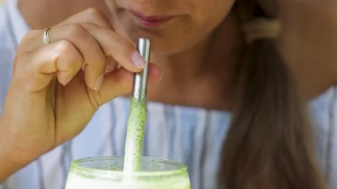 Drinking a mint smoothie out of a glass. Stock Footage 269514698