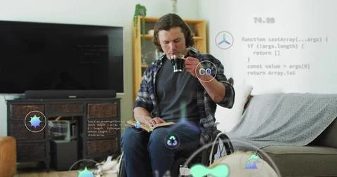 Drinking plaid-shirted man holding mug, turning notebook pages in wheelchair at 스톡 사진