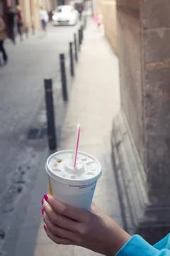 Drinking plastic cup with a straw and a hand Stock Photos