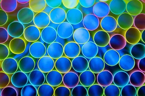 Drinking straw bundle from behind with colored illuminated, blue Stock Photos