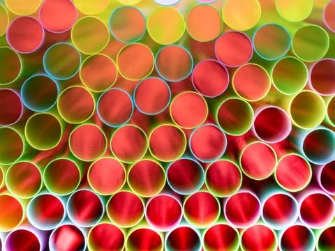 Drinking straw bundle from behind with colored illuminated, red Stock Photos