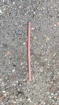 Drinking straw lying on textured ground Stock Photos