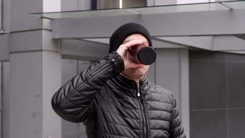 Drinking takeaway coffee and brooding looking at a smartphone Stock Footage 167168239