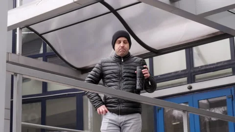 Drinking takeaway coffee and brooding looking at a smartphone Stock Footage 167168593