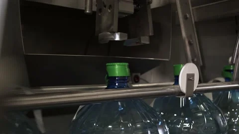 Drinking water bottling production. Remove the plastic cap from the bottle. Stock Footage 162975630