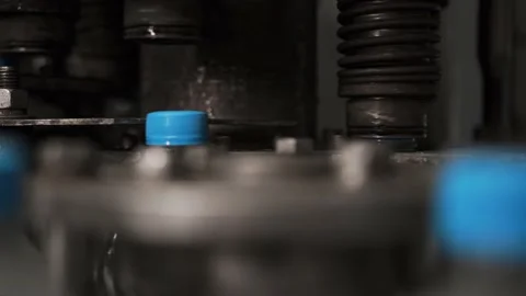 Drinking water bottling production. Screws the plastic cap onto the bottle. Stock Footage 162760176