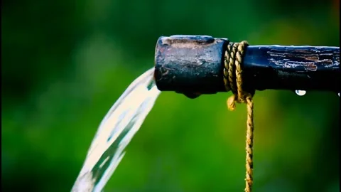 Drinking Water flowing out of pipe. Natural green out of focus bokeh backgrou Stock Footage 134182087