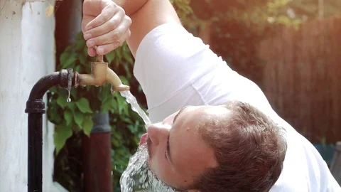 Drinking water out of old water tap faucet - slow motion shot Stock Footage