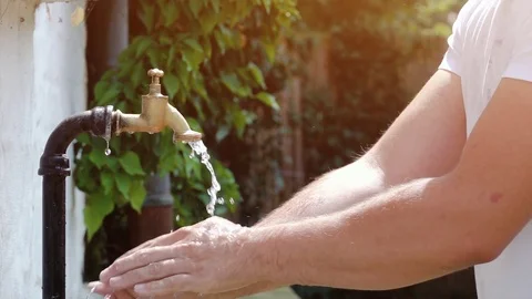 Drinking water out of old water tap faucet - slow motion shot Stock Footage