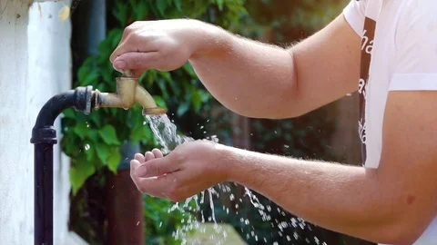 Drinking water out of old water tap faucet - slow motion shot Stock Footage