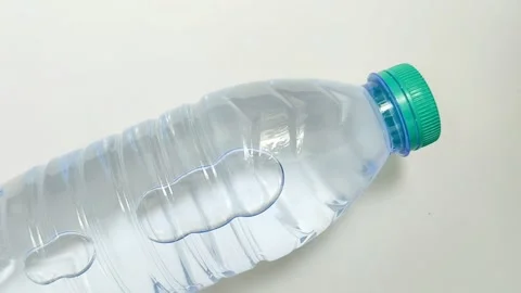 Drinking water in a plastic bottle on a white background Видео 310868879