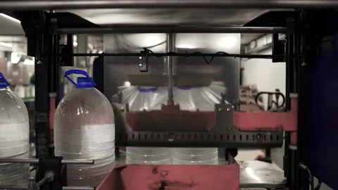 Drinking water production. Bottles packed with polyethylene sending supermarket Stock Footage 162974698