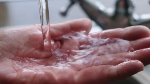 Drinking water from the tap flows into the woman's hand Video stock 150044874