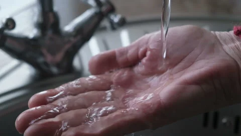 Drinking water from the tap flows into the woman's hand Video stock 150049876