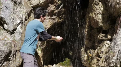 Drinking from a waterfall in the mountains during a trek Stock Footage 49129289