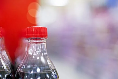 Drinks in plastic bottles on a red background at a supermarket Stock Photos