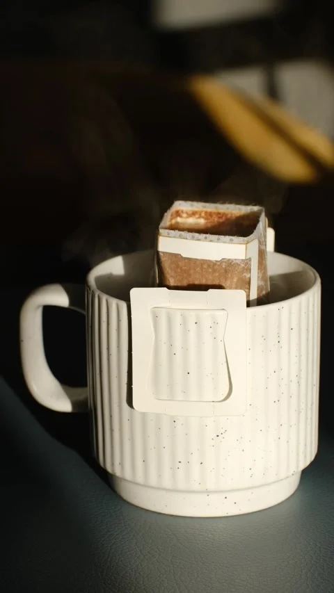 Drip coffee bag brewing in a ceramic mug Stock Footage 337545941