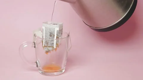Drip coffee bag, brews coffee in a glass mug on a pink background Vídeos de archivo 218243255