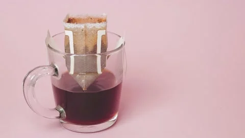 Drip coffee bag, brews coffee in a glass mug on a pink background Vídeos de archivo 218243609
