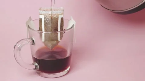 Drip coffee bag, brews coffee in a glass mug on a pink background Vídeos de archivo 218243711