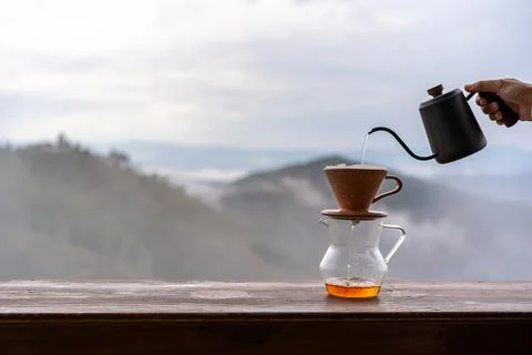 Drip coffee with beautiful mountains view and mist in the morning on wooden.. Fotos de archivo