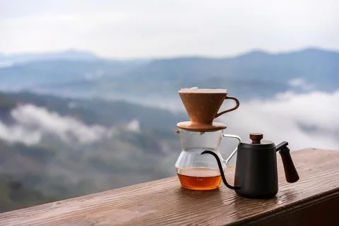 Drip coffee with beautiful mountains view and mist in the morning on wooden.. Fotos de archivo