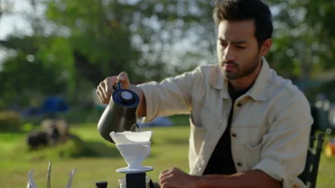 Drip coffee brewed when camping outdoors, coffee poured into a filter cup Stock Footage 231647530