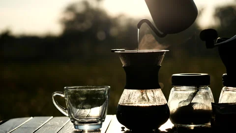 Drip coffee brewing while outdoor camping, pouring hot water from kettle Stock Footage 145868667
