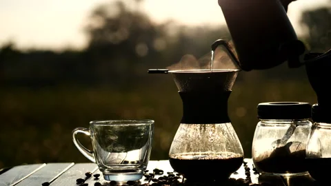 Drip coffee brewing while outdoor camping, pouring hot water from kettle Stock Footage 145868721