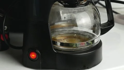 The drip coffee maker brews coffee.Drops fall into a transparent teapot. Stock Footage 143522735