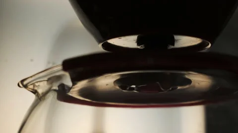 Drip coffee maker brews freshly brewed coffee. Drops of coffee drip slowly into Stock Footage 142484205