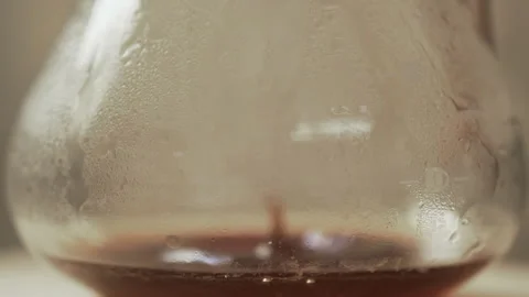 Drip freshly brewed coffee drips from a paper filter into the kettle. Stock Footage 186950431